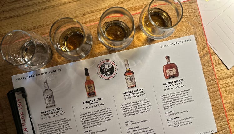 Glasses of bourbon accompanied by an information card, set up for a tasting experience at Cascade Hollow Distilling Co.