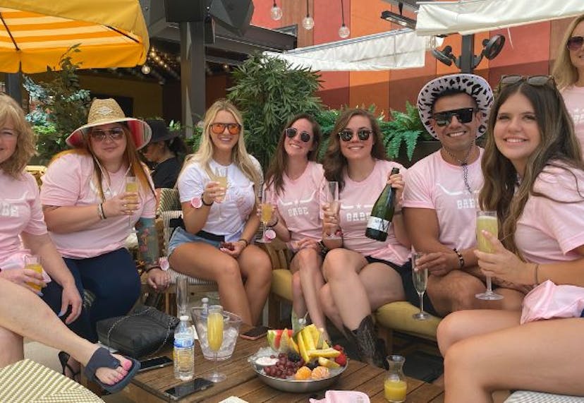 A group of people celebrating a bachelorette party, smiling and posing together for the camera.
