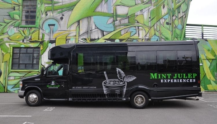 A Mint Julep Experiences luxury tour vehicle parked in front of a vibrant Nashville mural.