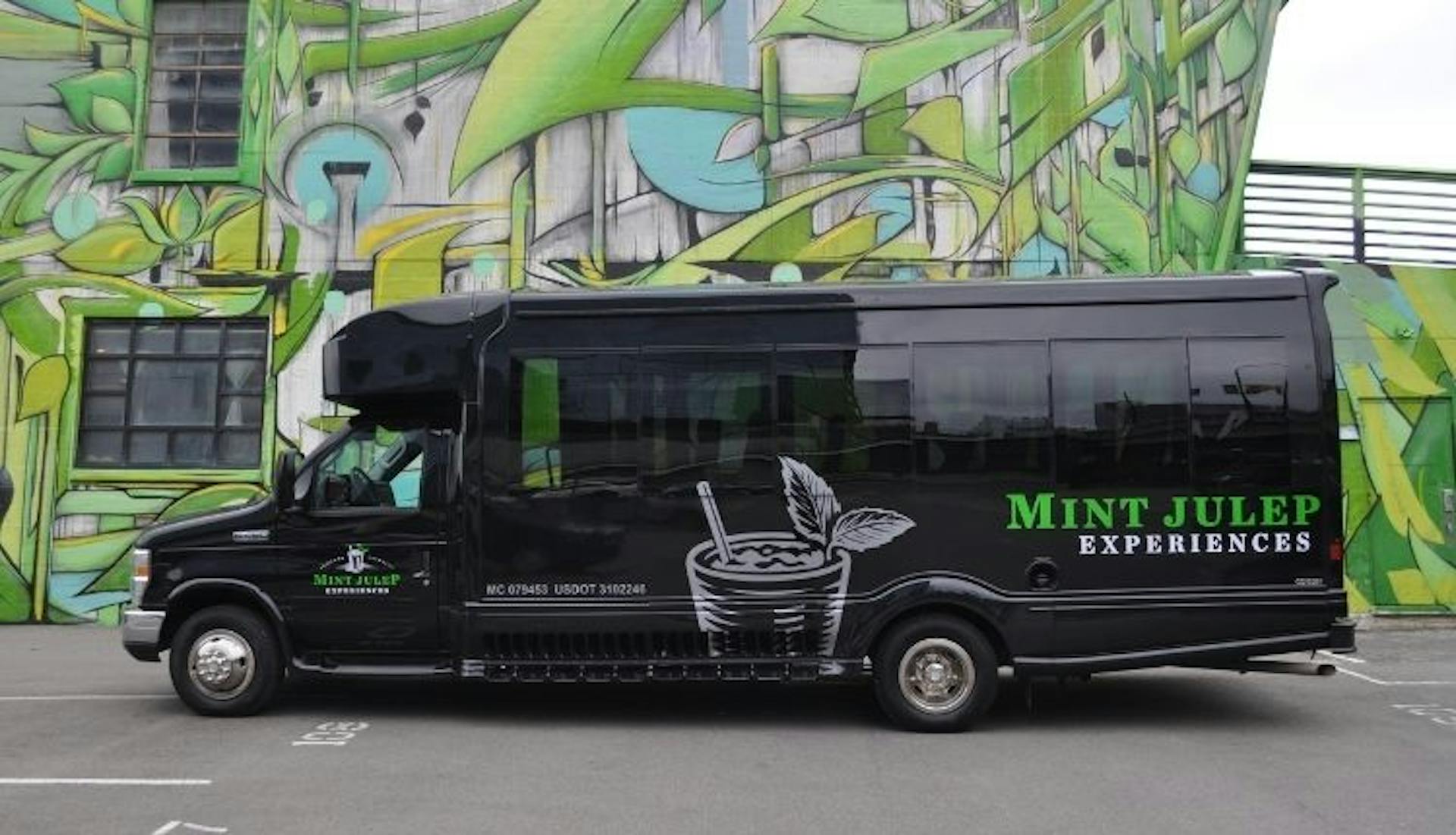 A Mint Julep Experiences luxury tour vehicle parked in front of a vibrant Nashville mural.