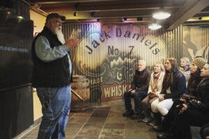 A tour leader speaking to an attentive group at the Jack Daniel's Distillery in Lynchburg, Tennessee.