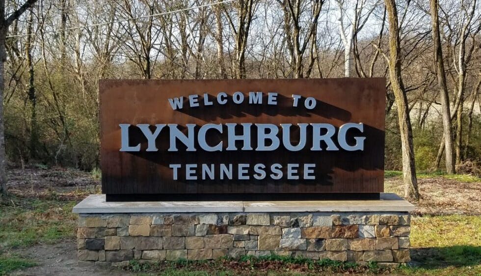 A sign reading "Welcome to Lynchburg, Tennessee," marking the entrance to the historic town known for its whiskey heritage.