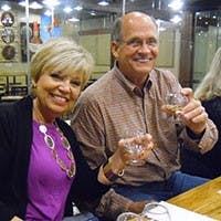 A couple, each holding a glass of bourbon, enjoying the moment.