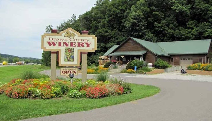 The exterior of Brown County Winery, showcasing its rustic charm with a welcoming facade set against a backdrop of lush greenery.