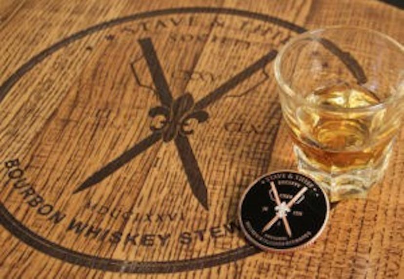 The Stave & Thief Bourbon Whiskey Steward logo displayed on a wooden surface.