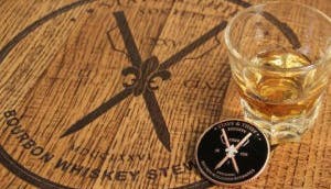 The Stave & Thief Bourbon Whiskey Steward logo displayed on a wooden surface.