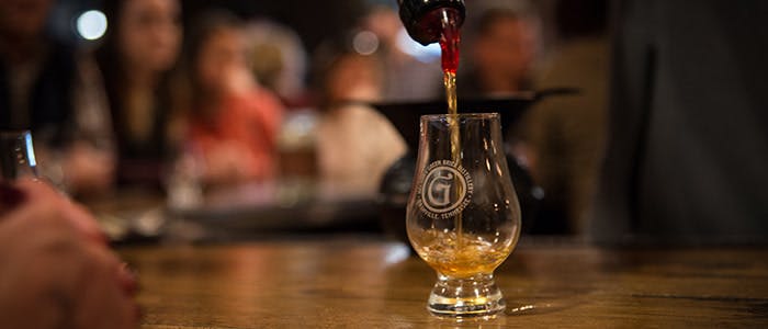 A drink being poured into a glass at Nelson’s Green Brier Distillery, capturing the rich amber color and craftsmanship of the bourbon.