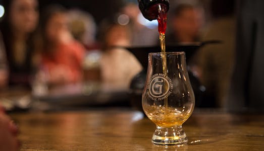 A drink being poured into a glass at Nelson’s Green Brier Distillery, capturing the rich amber color and craftsmanship of the bourbon.