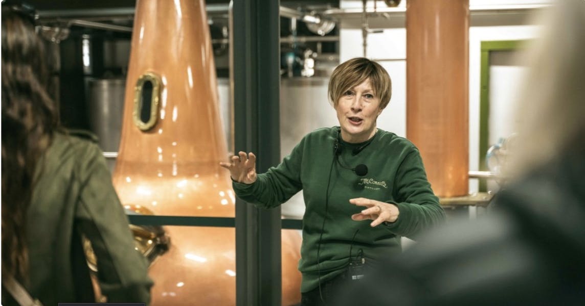 A guide speaking to visitors during a tour at McConnell’s Distillery.