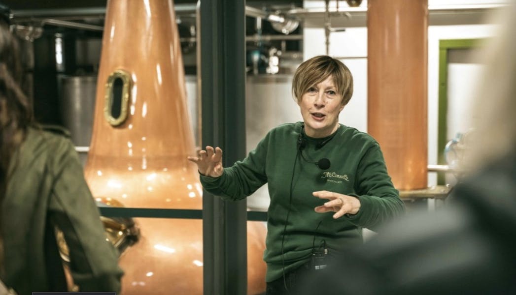 A guide speaking to visitors during a tour at McConnell’s Distillery.