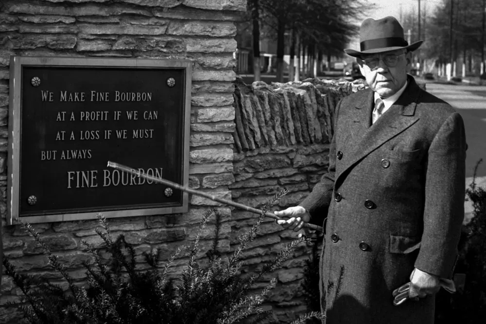Pappy Van Winkle poses next to a plague