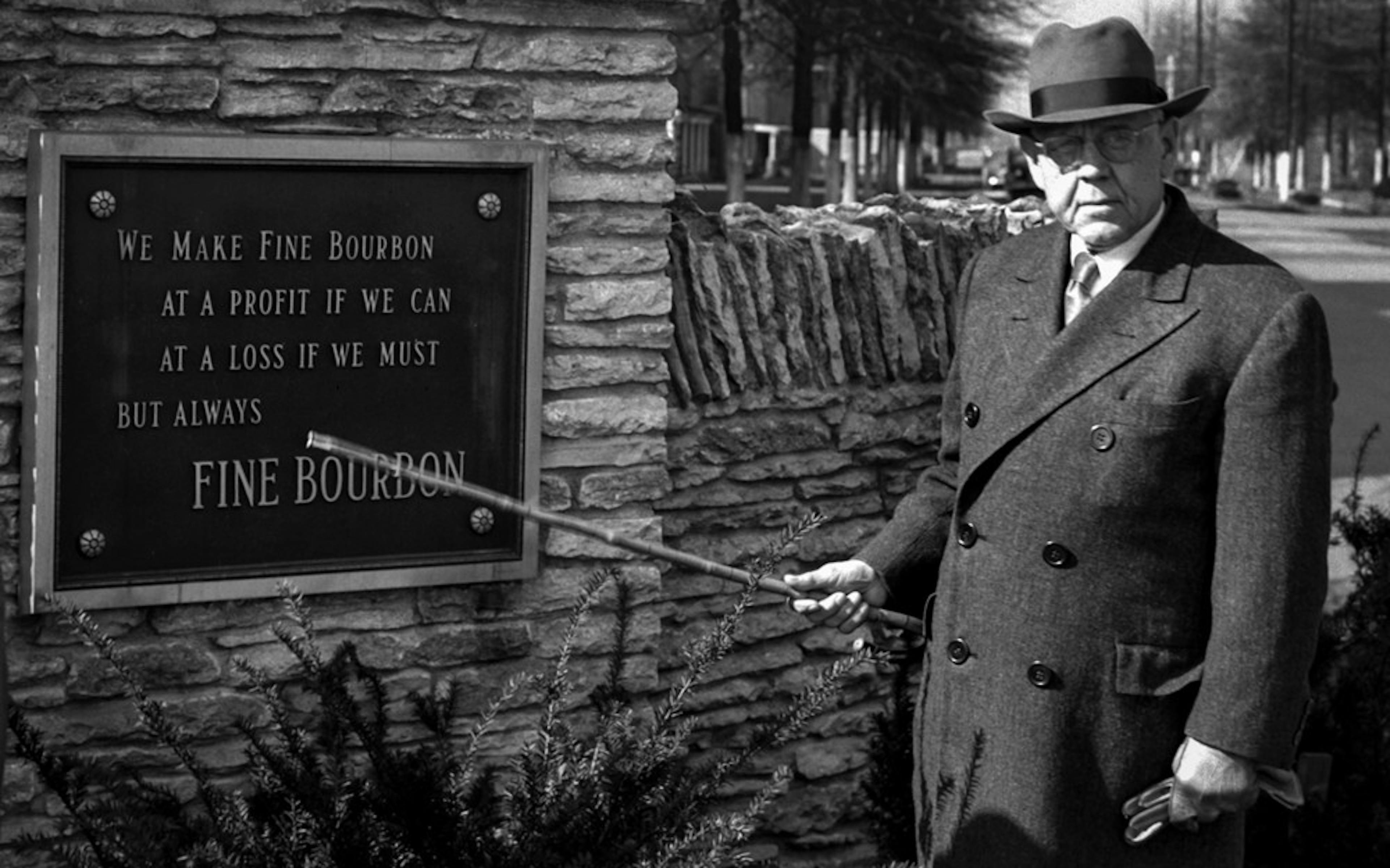 Pappy Van Winkle poses next to a plaque
