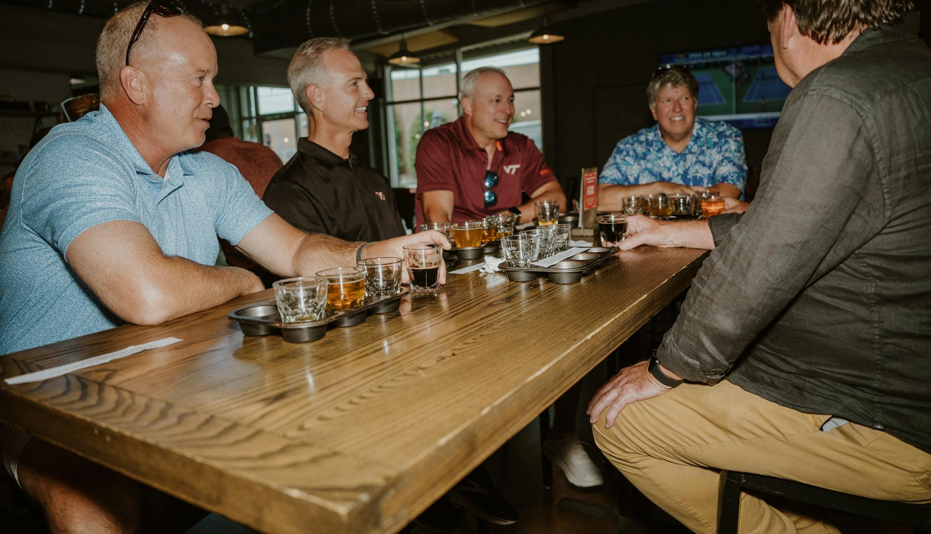 Group of men enjoying a whiskey tasting at a bar table.