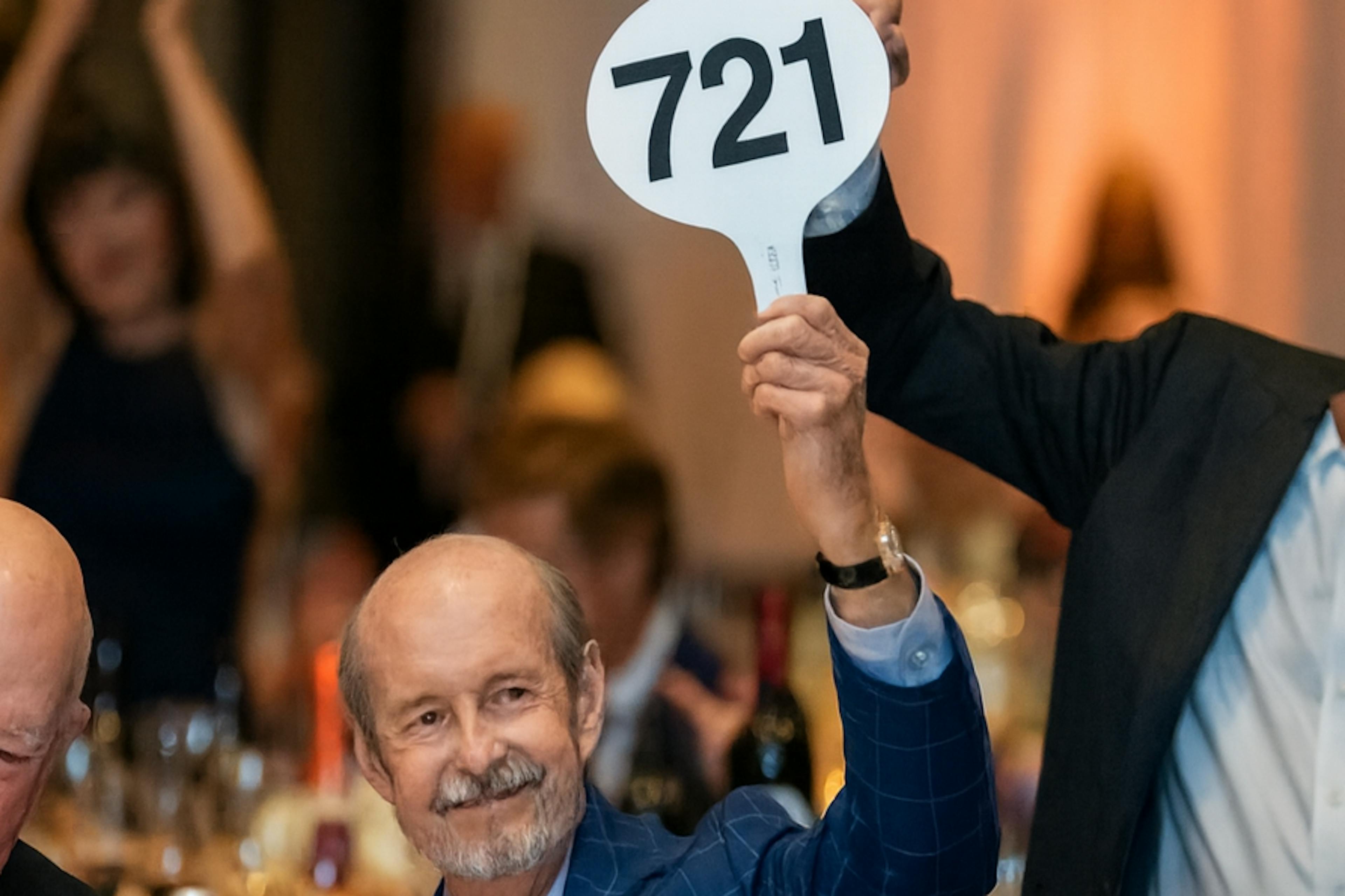 A man in a suit bids on an entire barrel of rare bourbon from buffalo trace