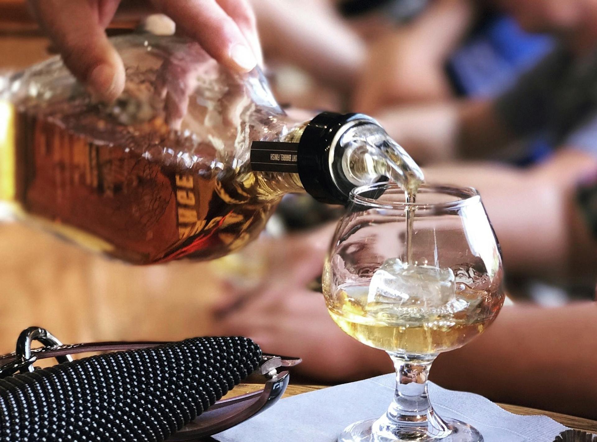 A bottle of angel's envy being poured for a tasting at a mint julep experiences tour of the distillery