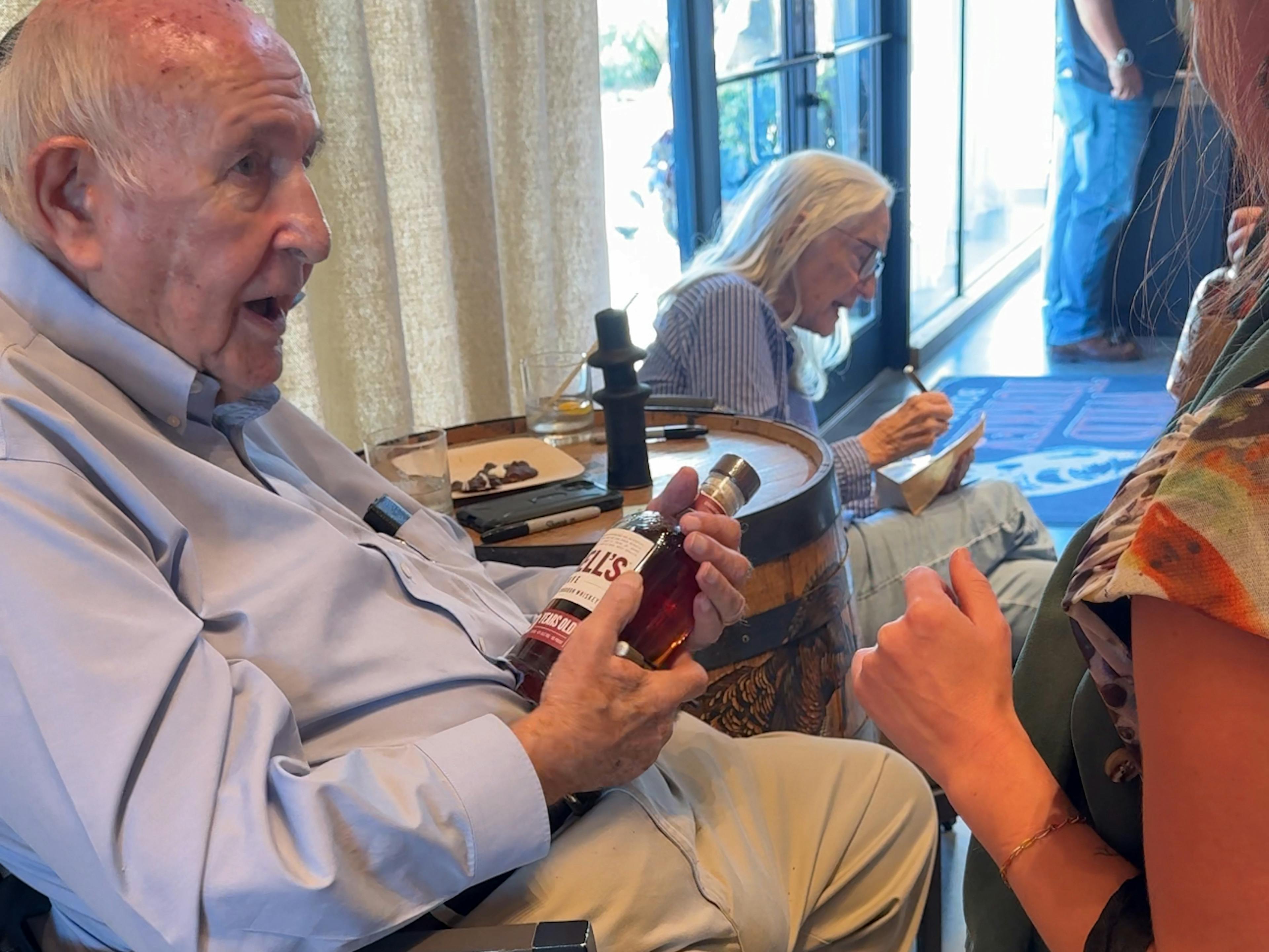 Jimmy Russell signing a bottle of Russell's Reserve at the end of a Mint Julep Experience's tour at Wild Turkey's Distillery