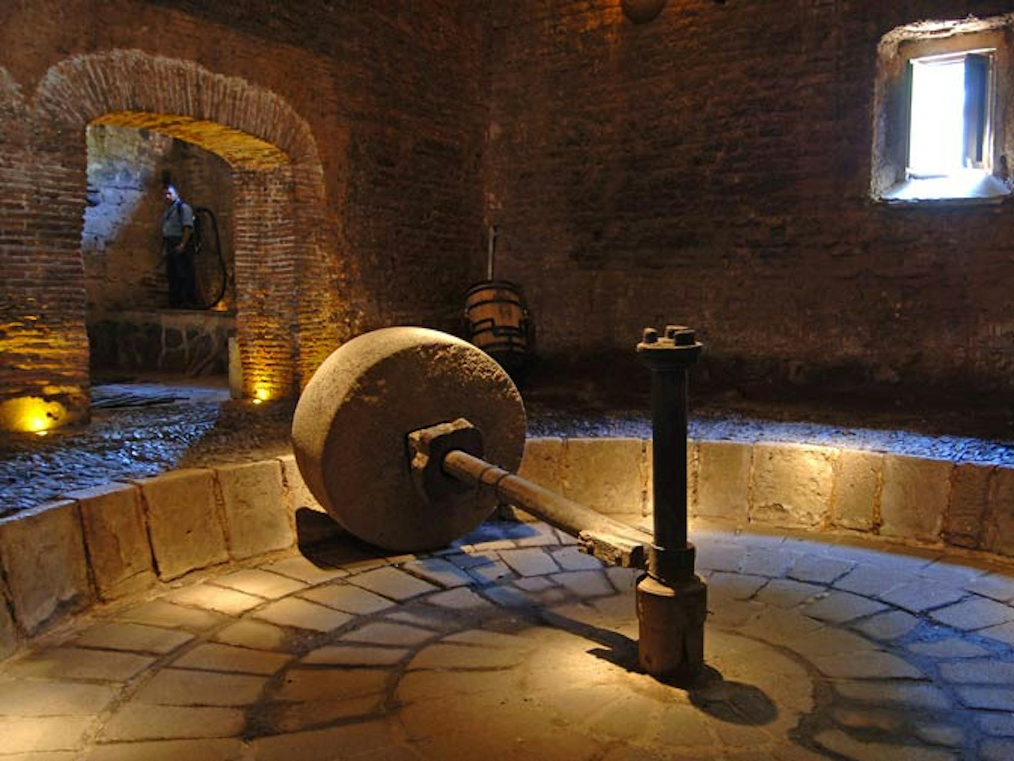 A heavy volcanic stone wheel (the tahona) to extract sweet, fibrous juice for tequila.