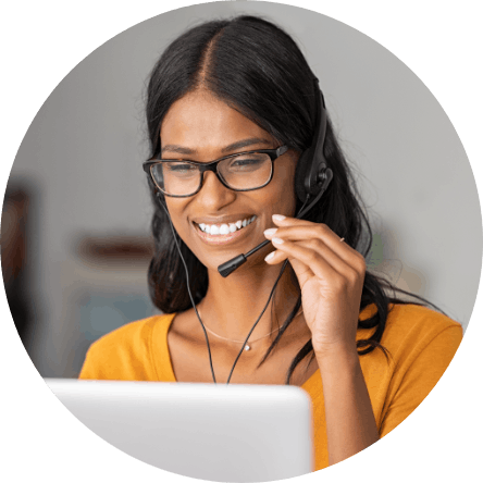 Customer service representative smiling and looking at a desktop computer