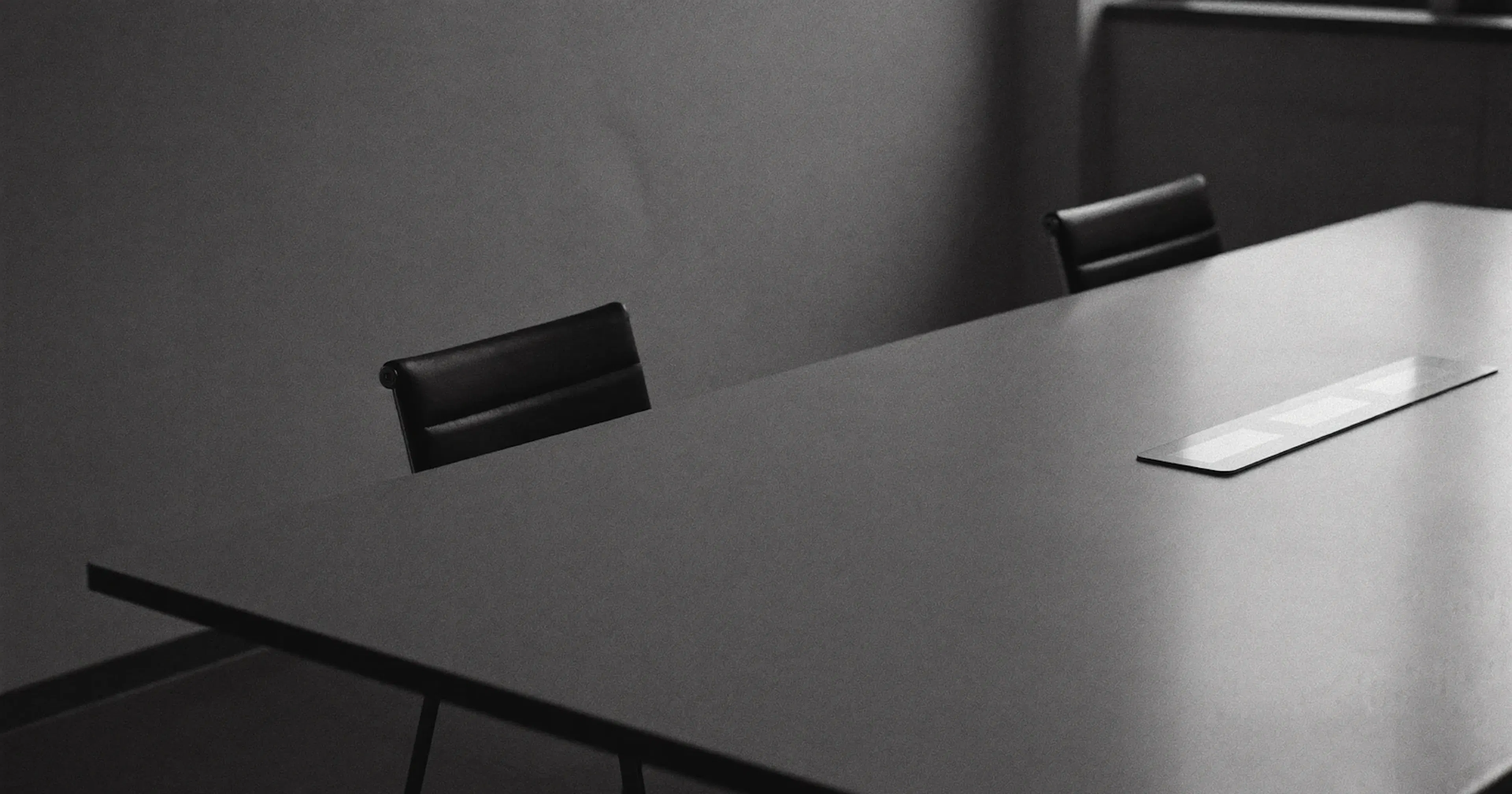 Table de conseil vide avec des chaises inoccupées après le départ d'un client majeur, noir et blanc