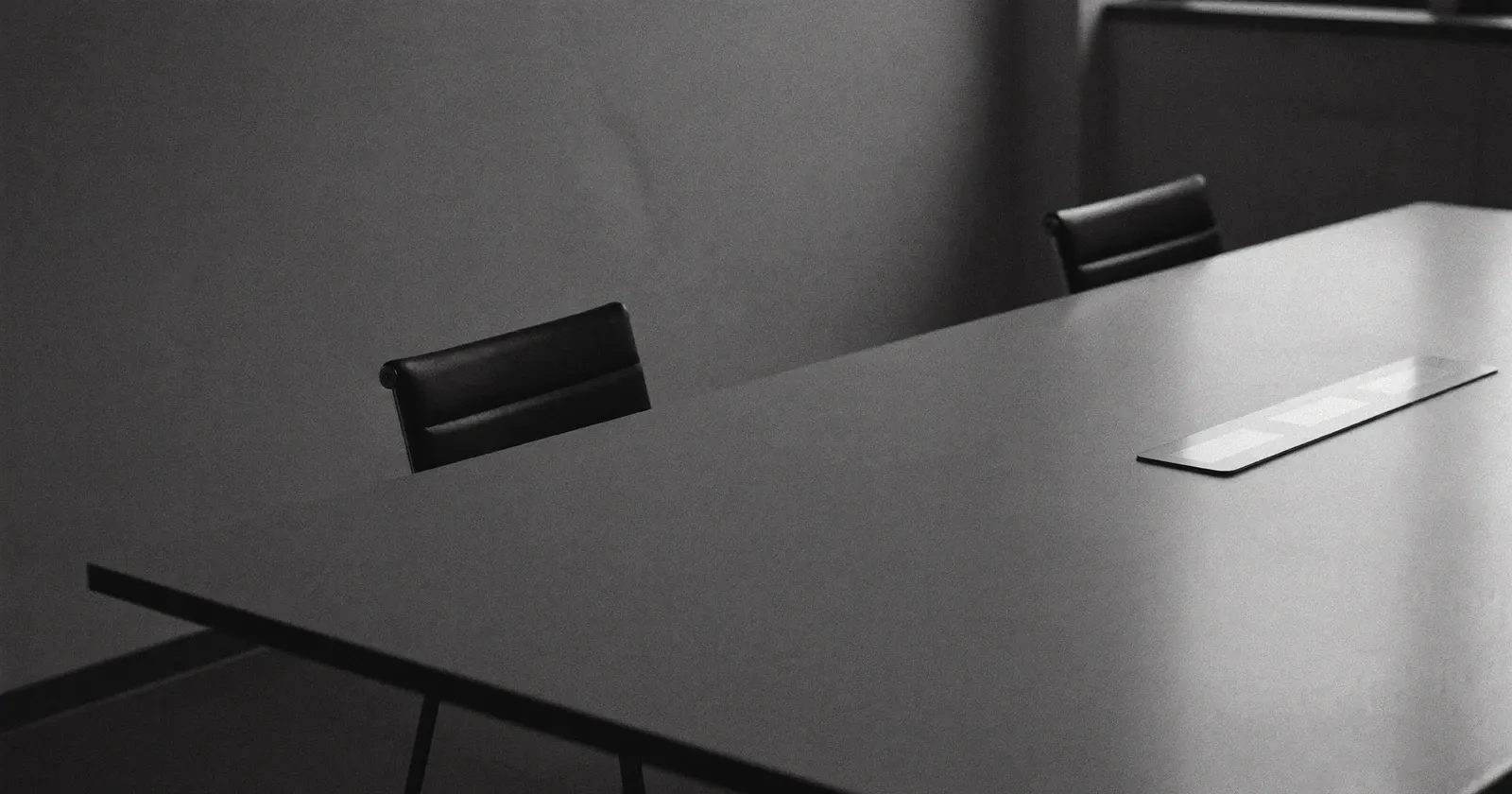 Table de conseil vide avec des chaises inoccupées après le départ d'un client majeur, noir et blanc