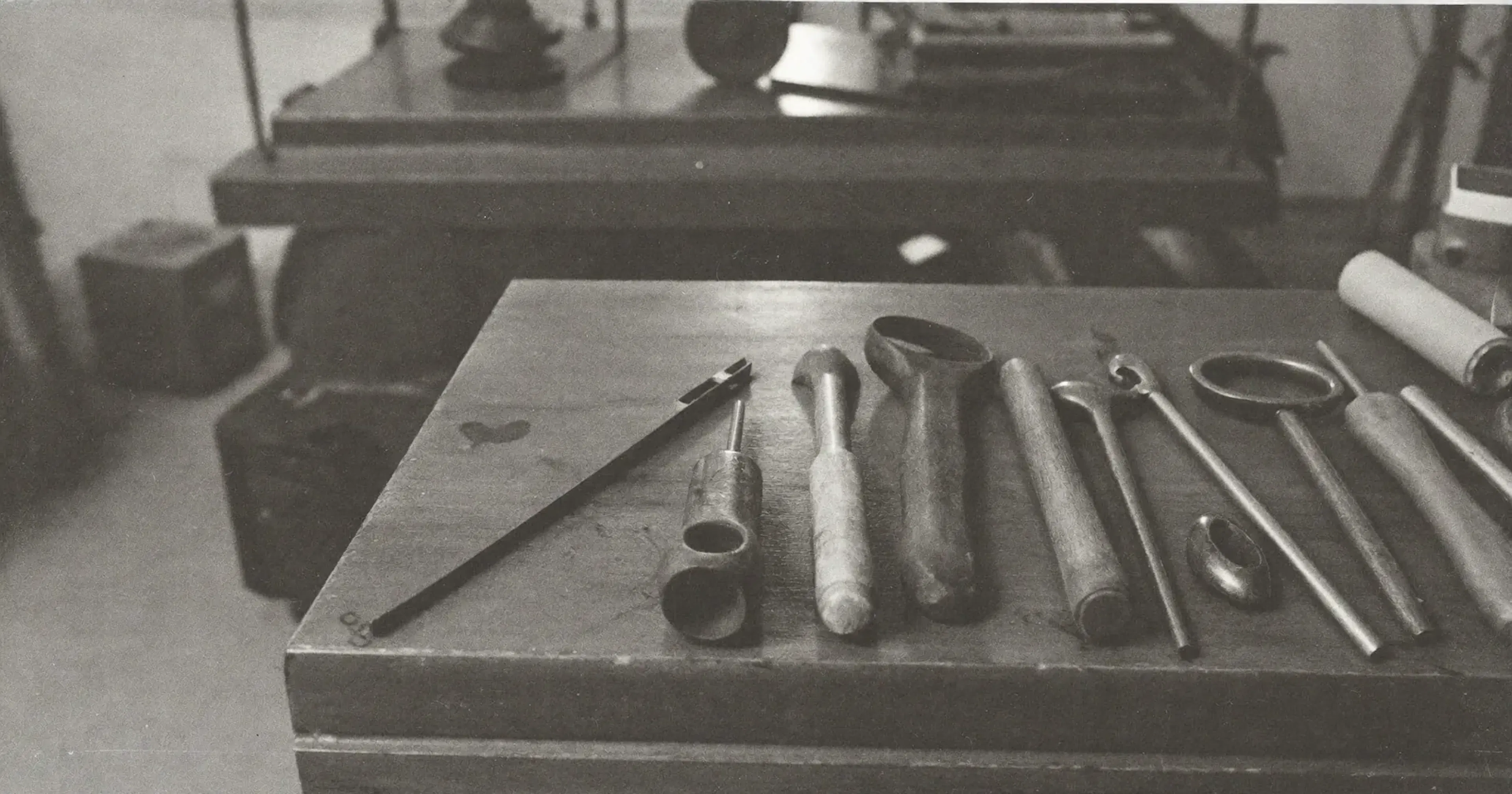 Tools laid on a workbench seen from the operator post, operator or advisor, embodied approach, contemplative black and white