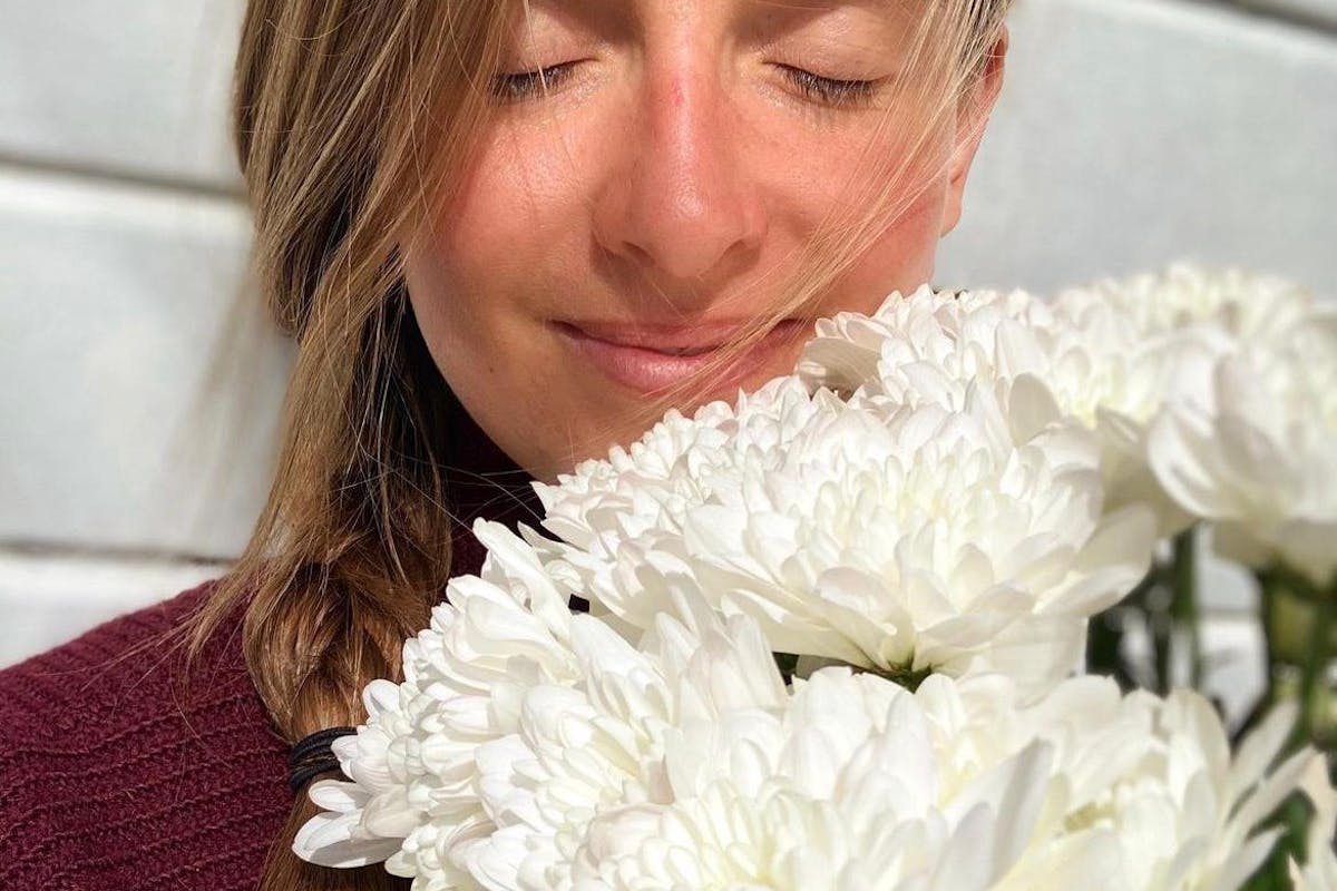 Jeska Onderwater mit geschlossenen Augen und weissen Blumen