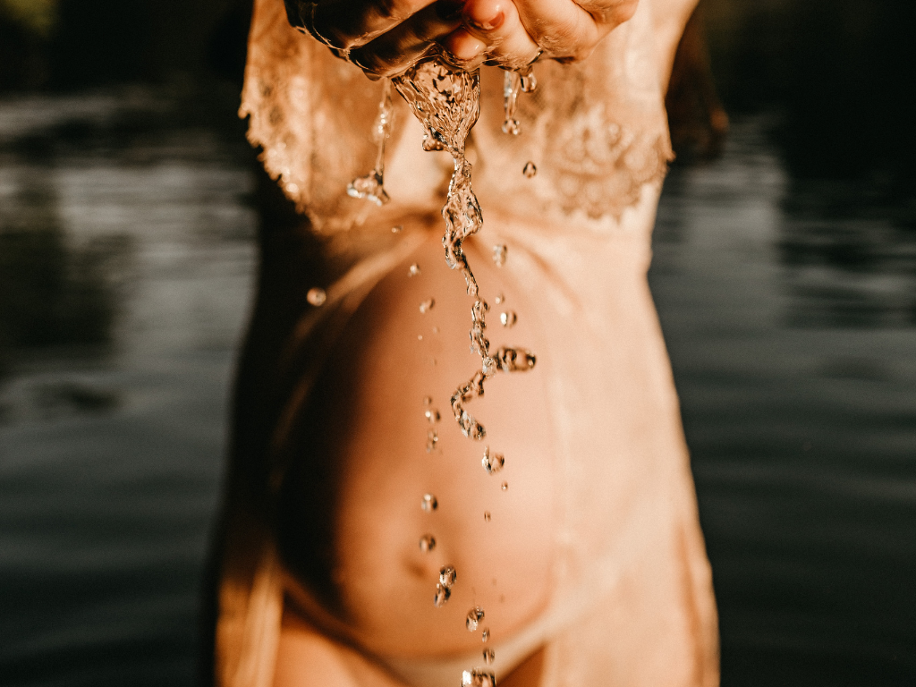 Schwangerer Bauch am Seewasser