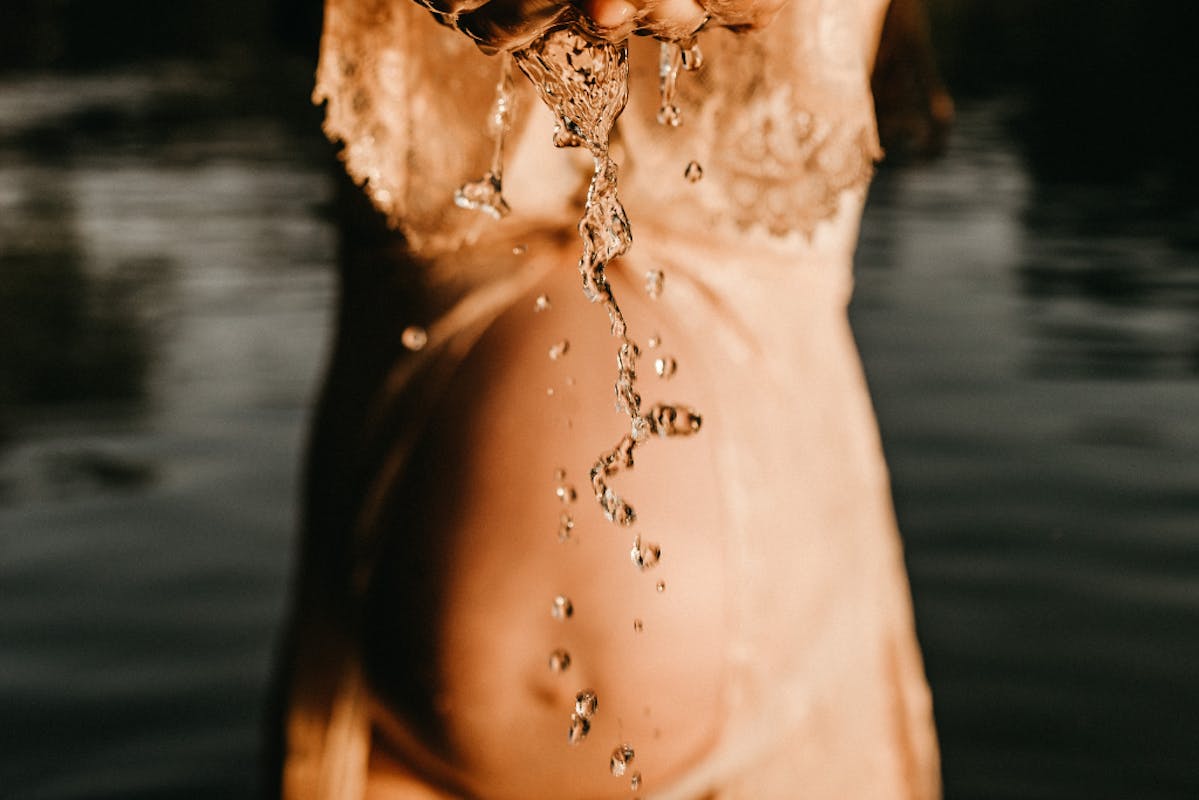 Schwangerer Bauch am Seewasser