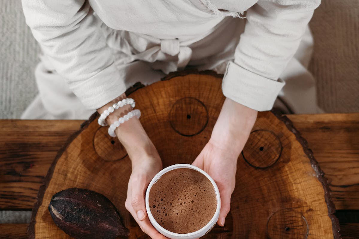 Frauenhände halten Tasse mit Kakao