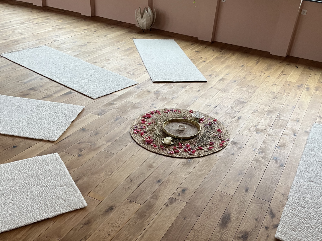 Holzboden des Studios mit ein paar Fellmatten und Teppich in der Mitte mit Blüten