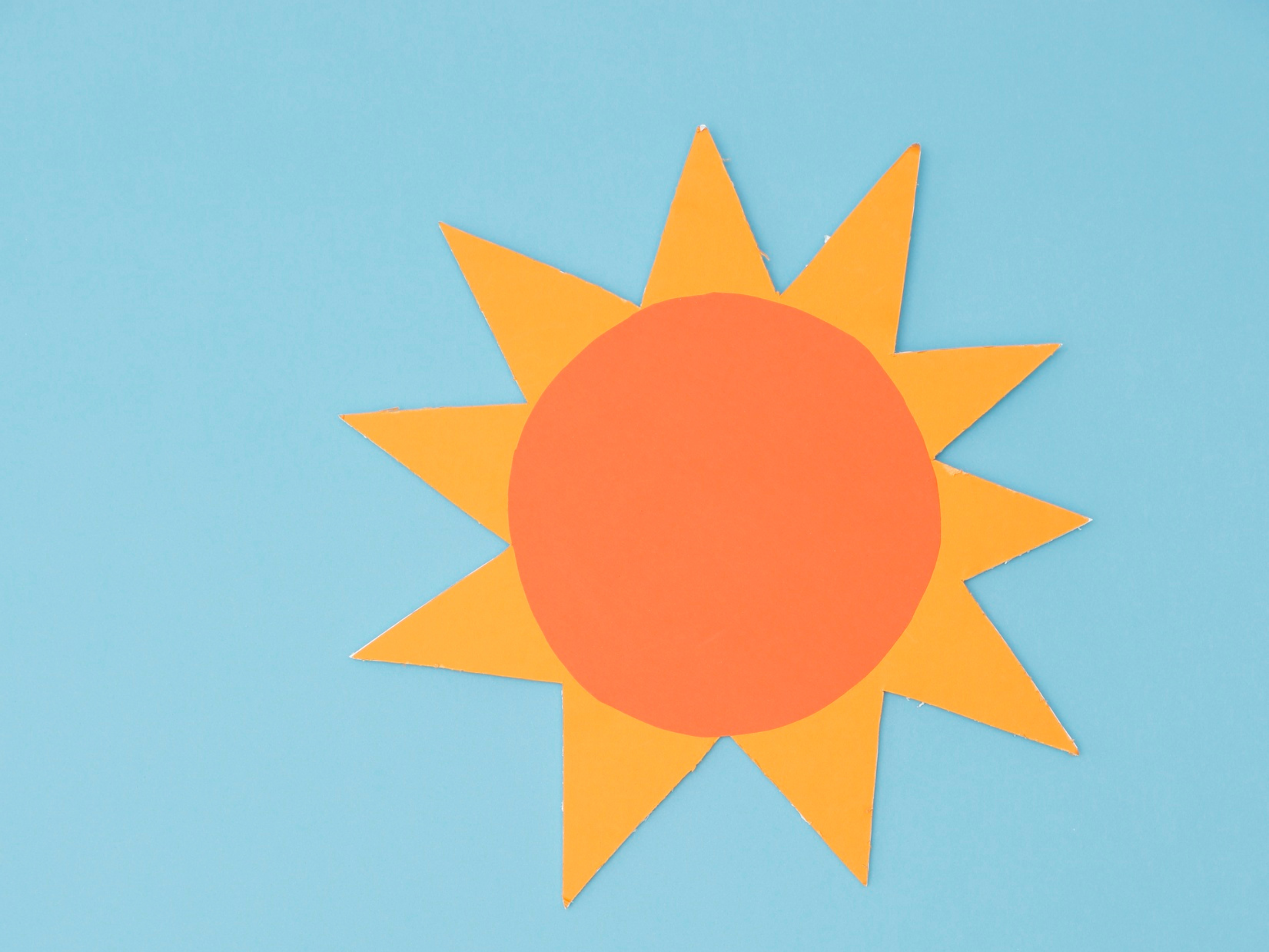 hellblauer Himmel und ein Sonnensymbol in orange-gelb