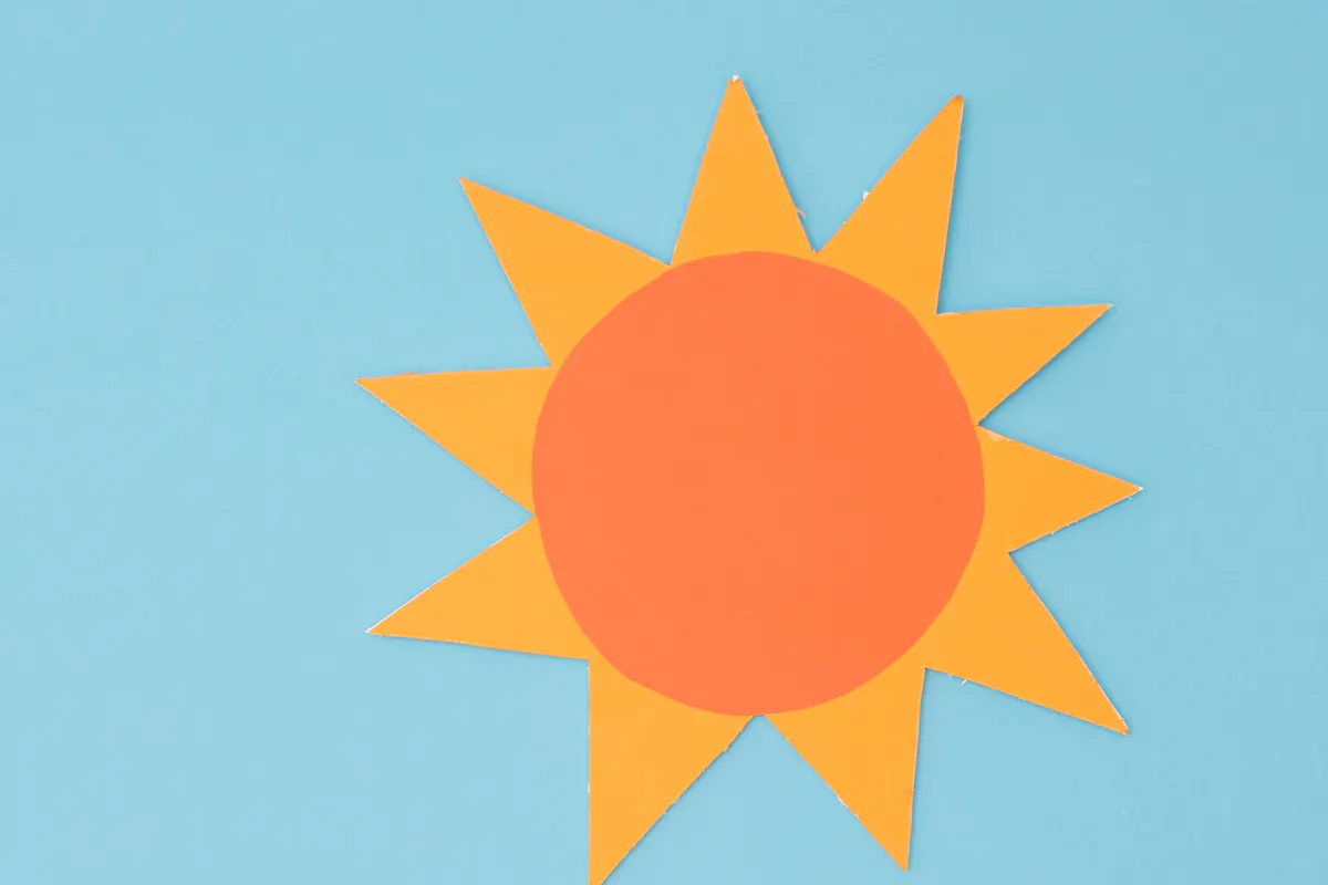 hellblauer Himmel und ein Sonnensymbol in orange-gelb