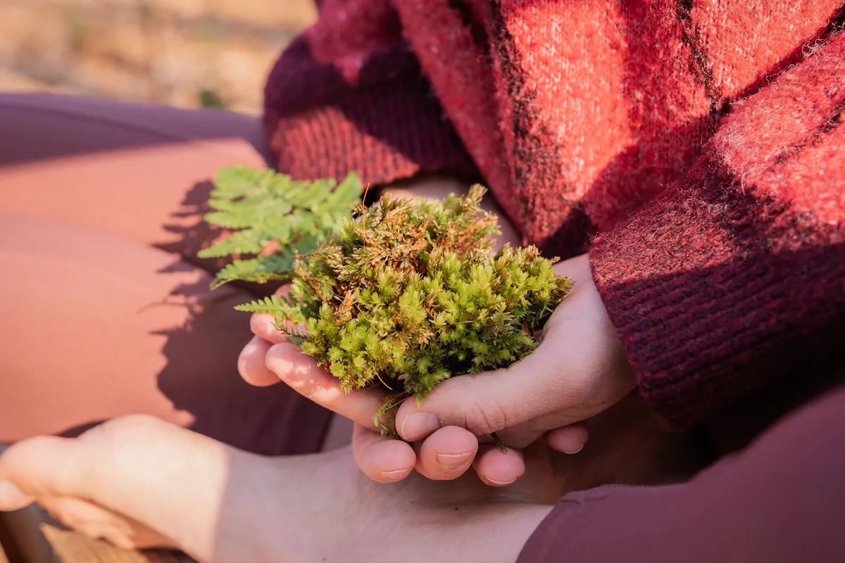 Dozentin hält Moss in ihren Händen in Höhe des Beckenbodens