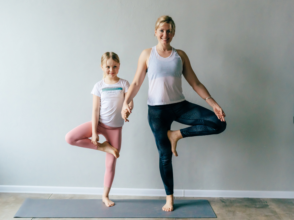 Mutter und Tochter nebeneinander in Baum Asana