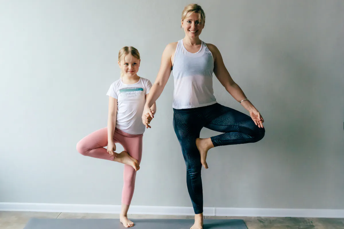 Mutter und Tochter nebeneinander in Baum Asana