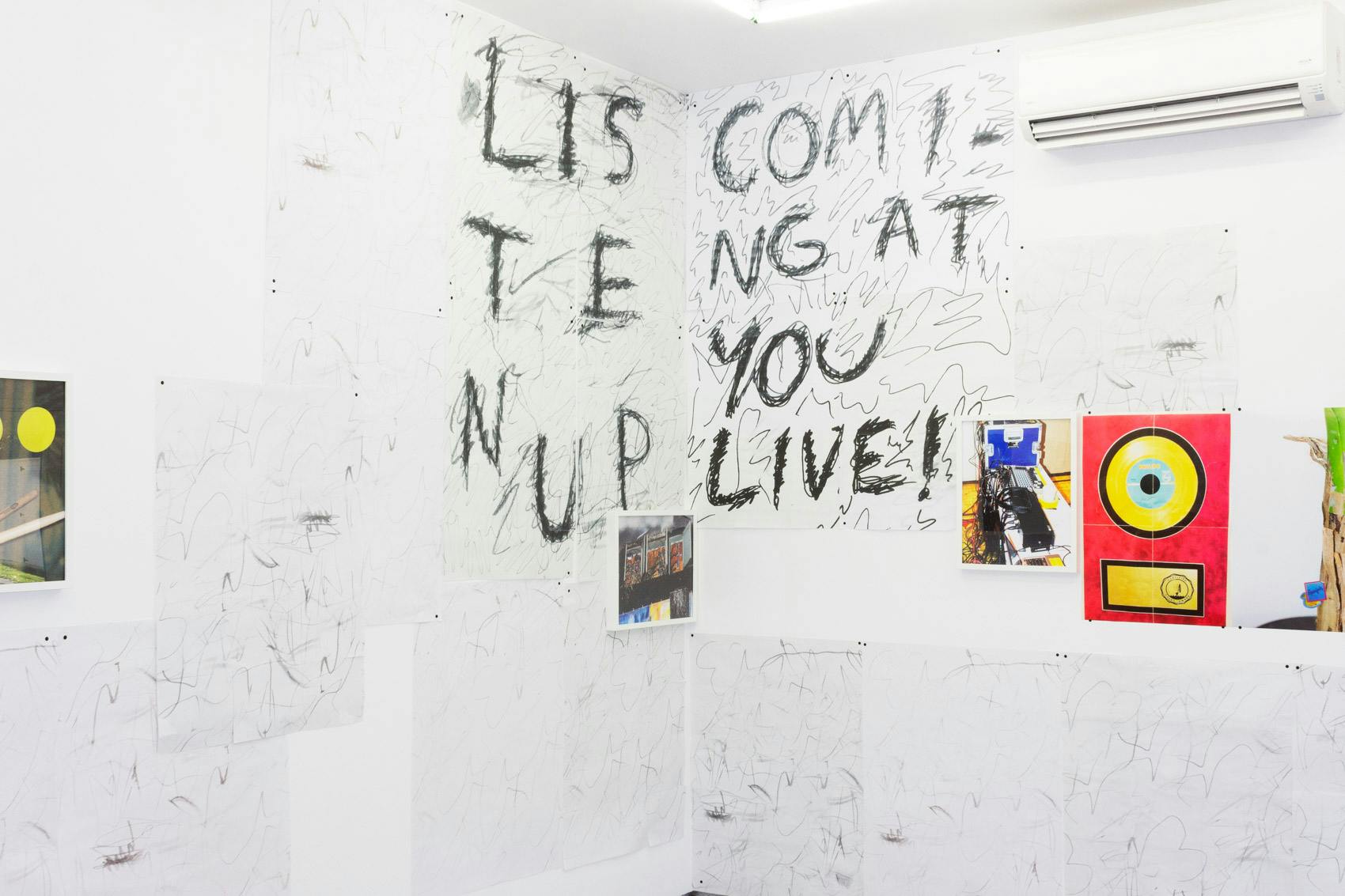 Installation shot of "A Concert" at Arcade On Stadium. Large white room with photographs and posters on the wall.