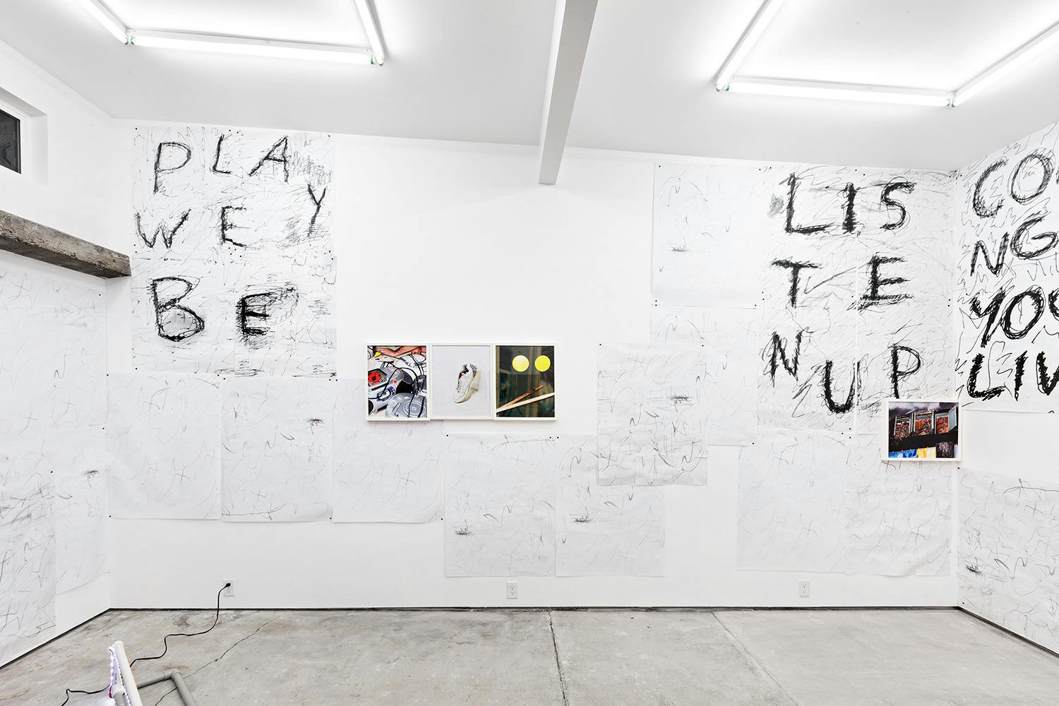 Installation shot of "A Concert" at Arcade On Stadium. Large white room with photographs and posters on the wall.