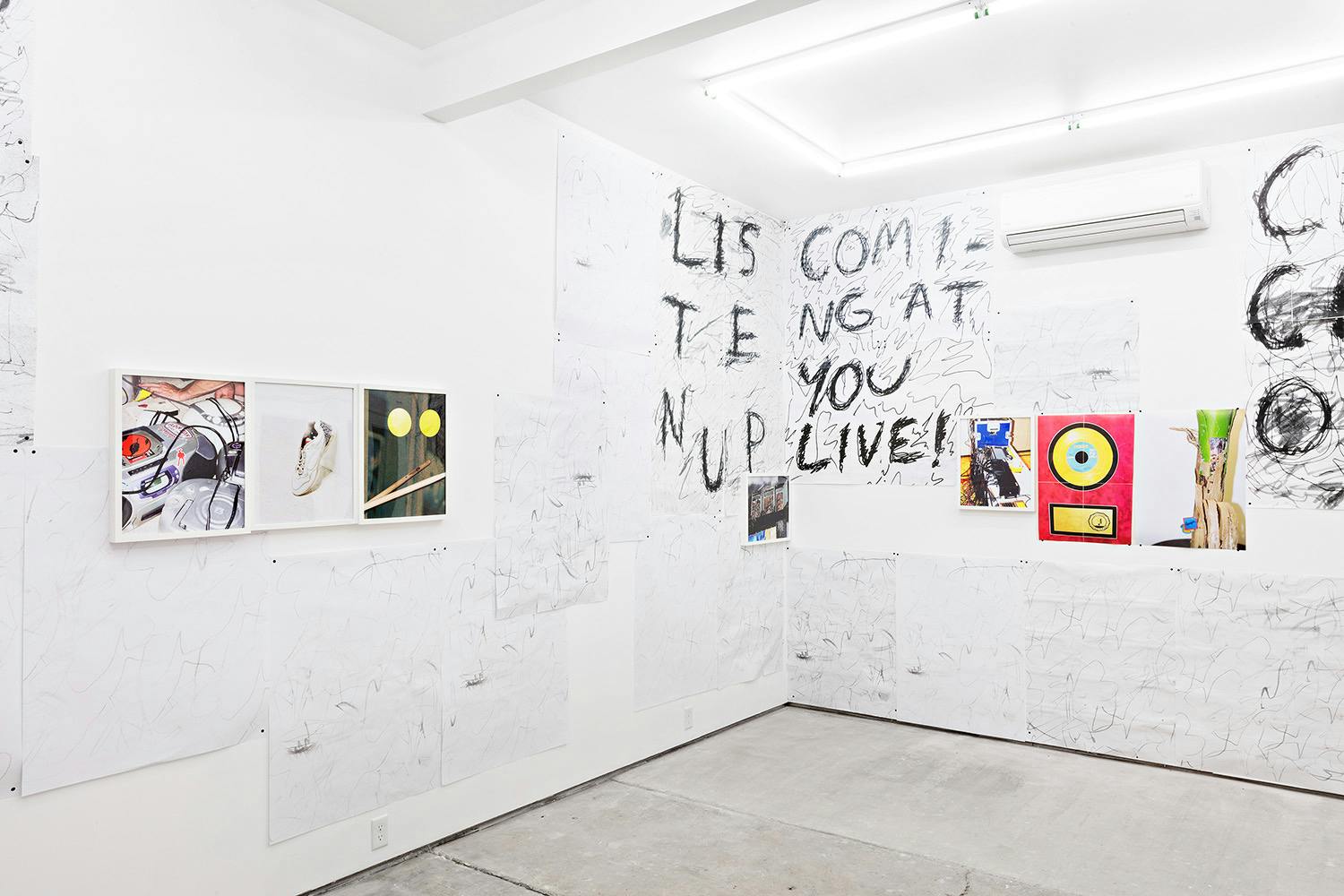 Installation shot of "A Concert" at Arcade On Stadium. Large white room with photographs and posters on the wall.