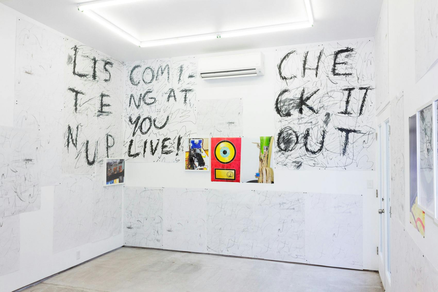 Installation shot of "A Concert" at Arcade On Stadium. Large white room with photographs and posters on the wall.