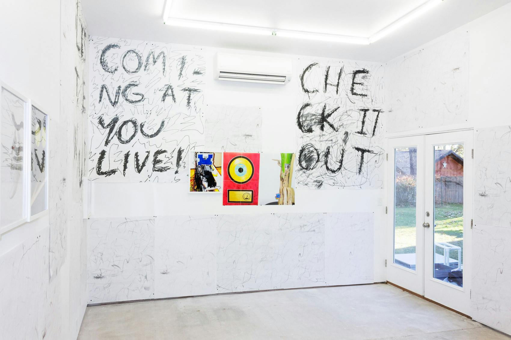 Installation shot of "A Concert" at Arcade On Stadium. Large white room with photographs and posters on the wall.