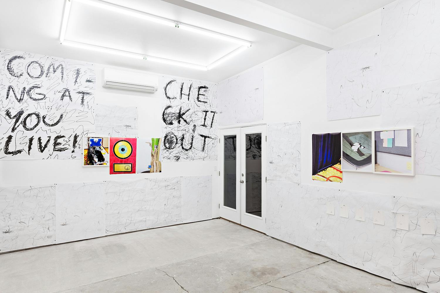 Installation shot of "A Concert" at Arcade On Stadium. Large white room with photographs and posters on the wall.