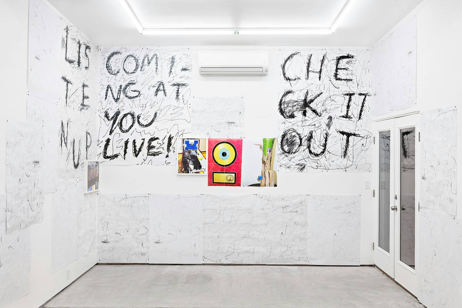 Installation shot of "A Concert" at Arcade On Stadium. Large white room with photographs and posters on the wall.