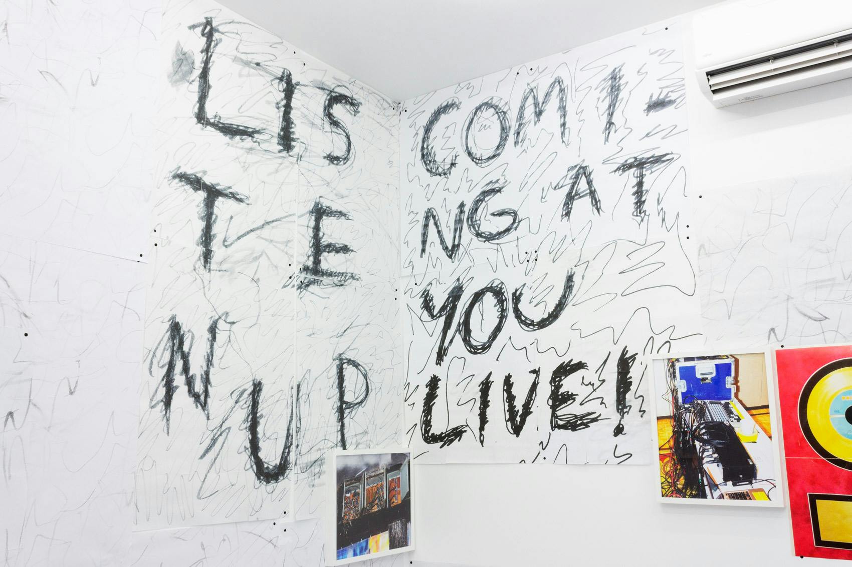 Installation shot of "A Concert" at Arcade On Stadium. Large white room with photographs and posters on the wall.