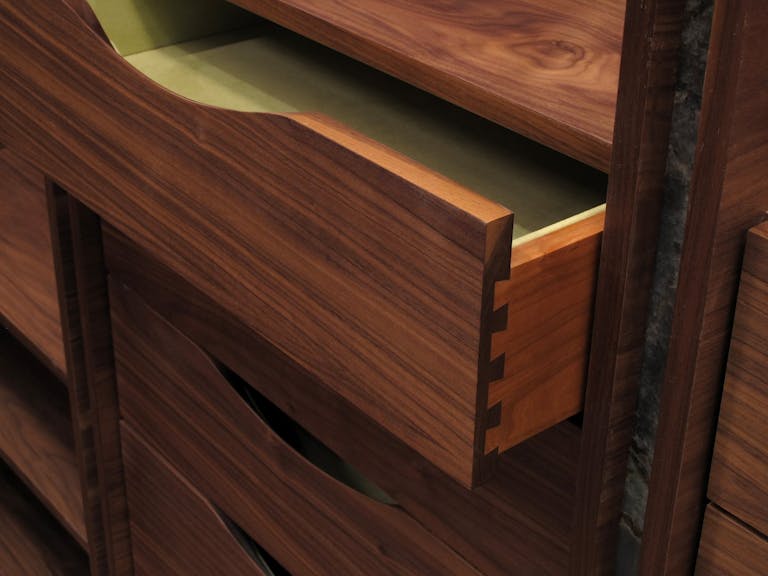 One drawer of four pulled out of cabinet to show the joinery to create the joint in the drawer. r