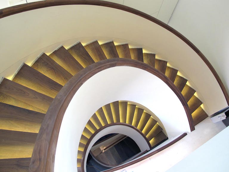 Stairway with yellow and brown stairs. Moving from left to right in an arch shape spanning many floors. 