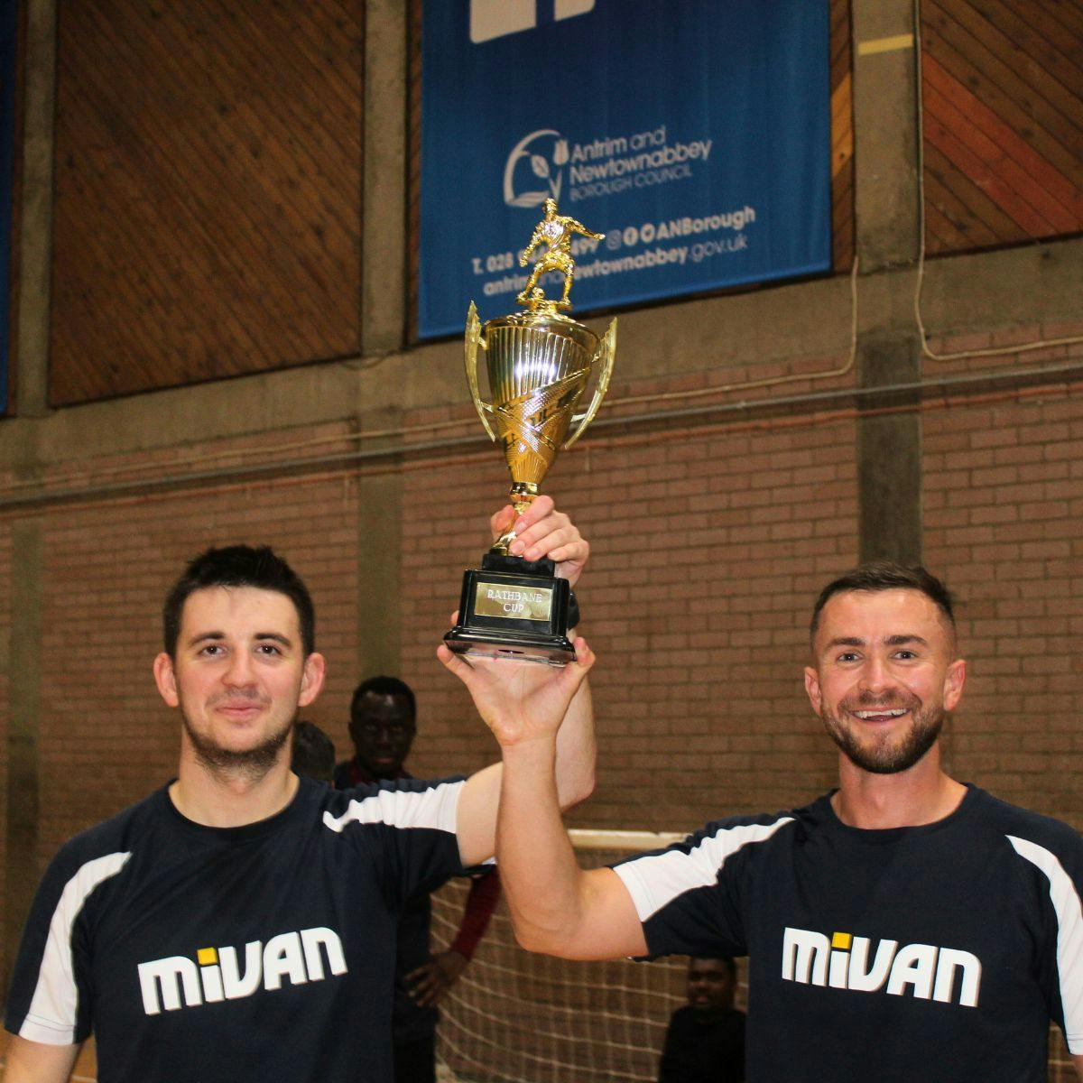 Two men hold trophy aloft.