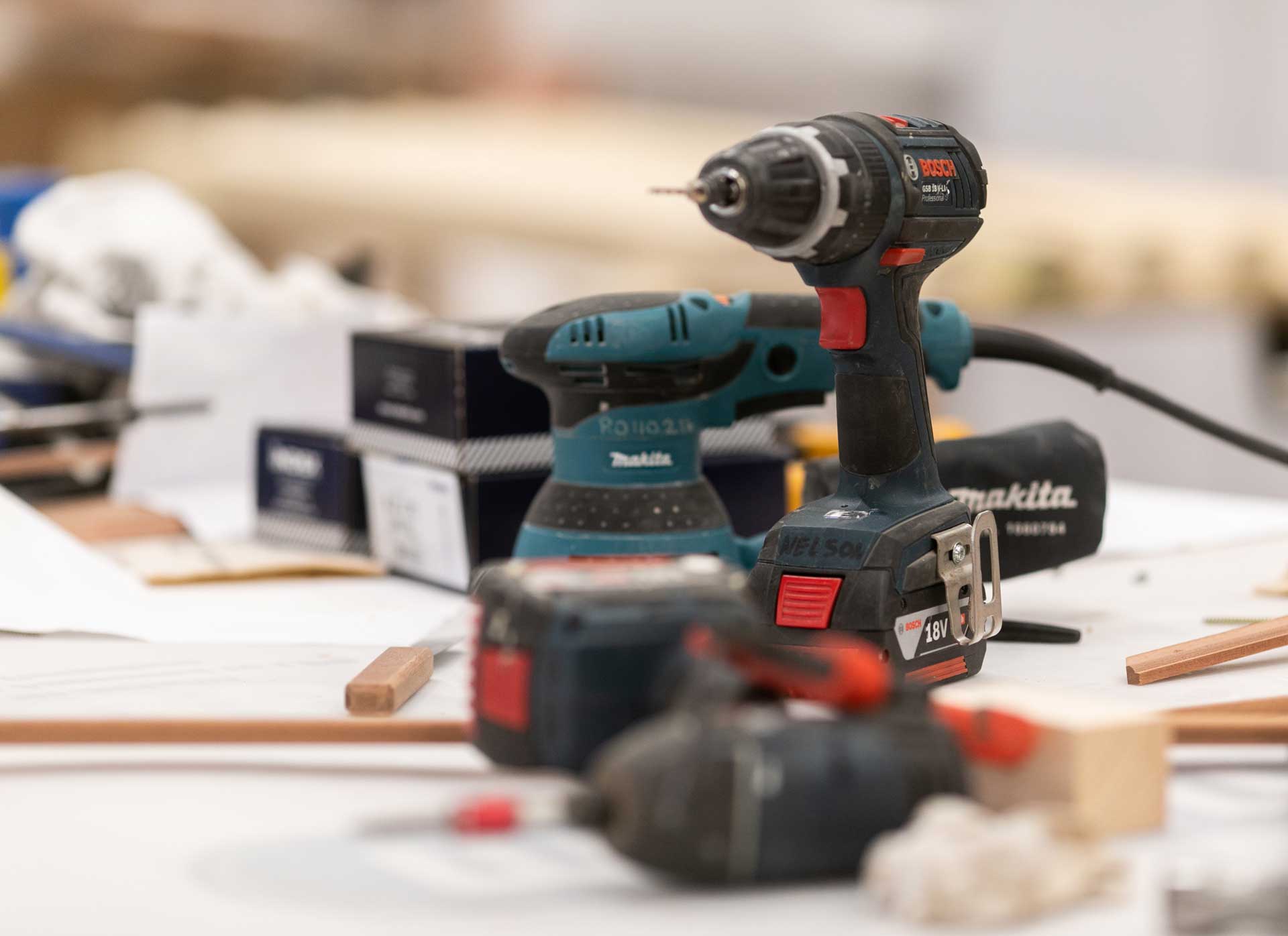 Drills and other electrical hand tools sitting on a work bench in the factory. 