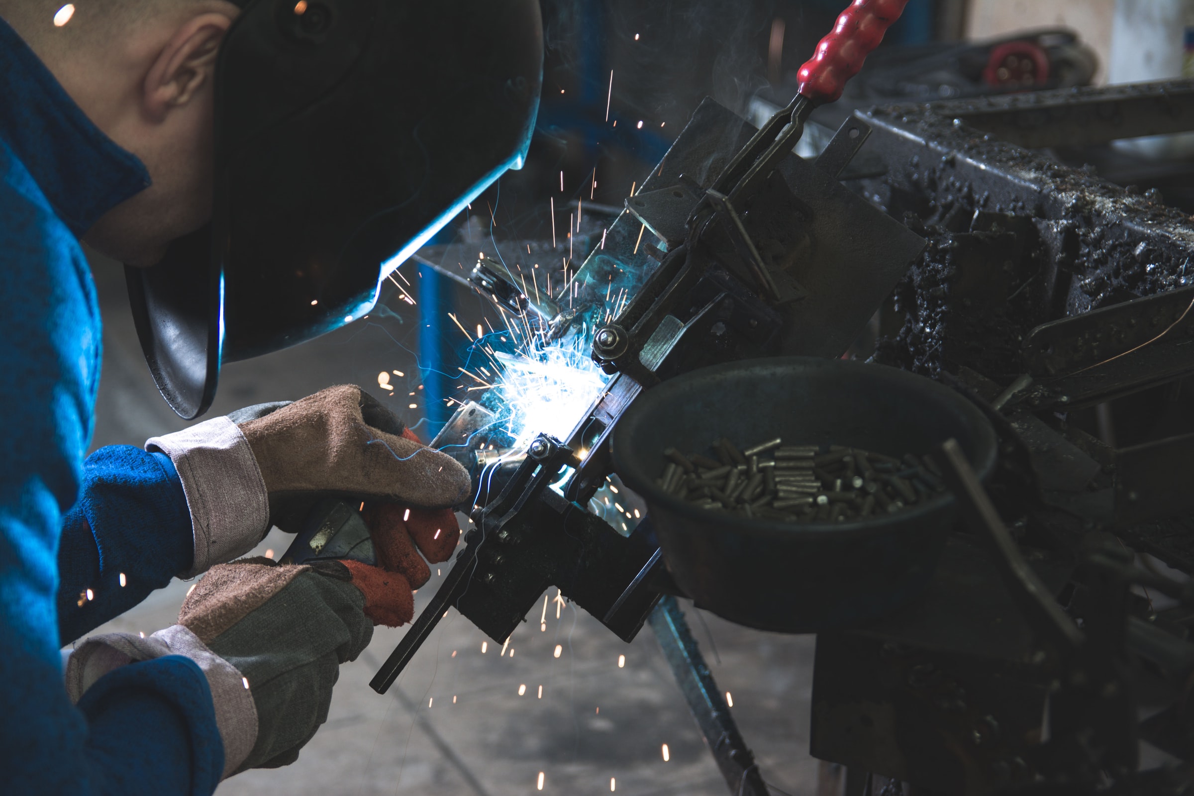 Person welding two pieces of metal together. Bright flash were the weld is happening. 