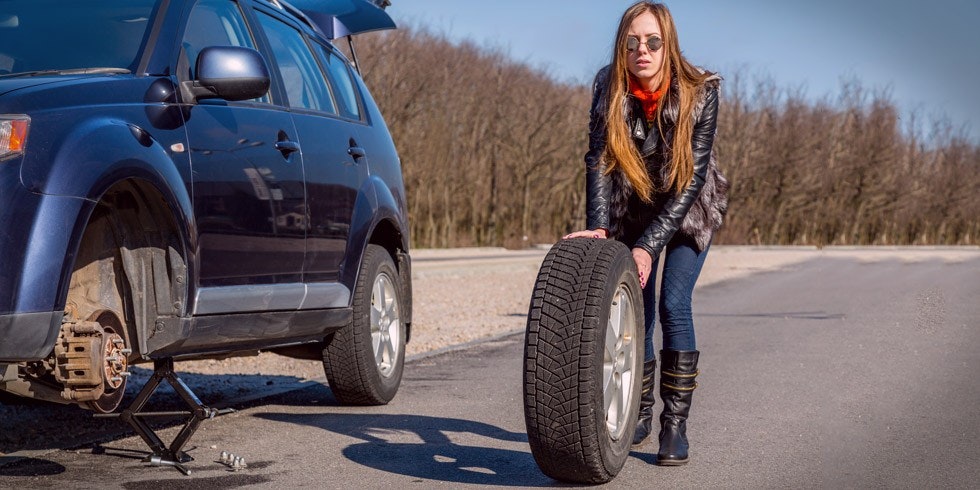 woman changing car tyre