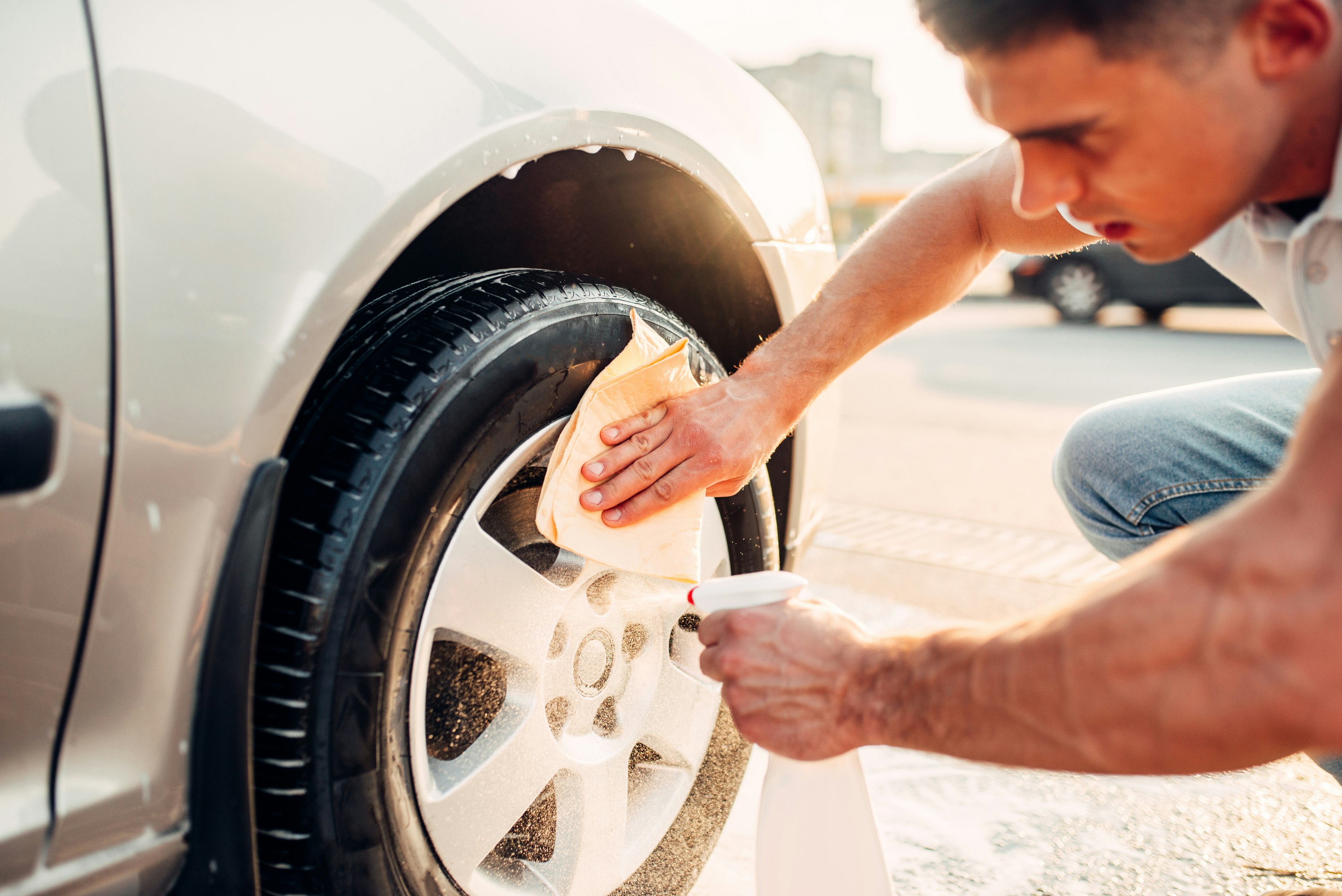 Man cleaning car rims